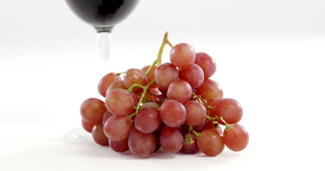 A symbolic image captures ripe grapes and a tipped wine glass, representing wine's journey. - Free Images, Stock Photos and Pictures on Pikwizard.com