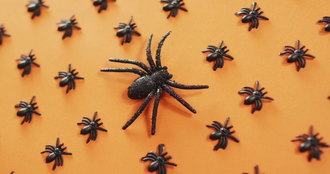 Close up view of multiple spider toys against orange background - Free Images, Stock Photos and Pictures on Pikwizard.com