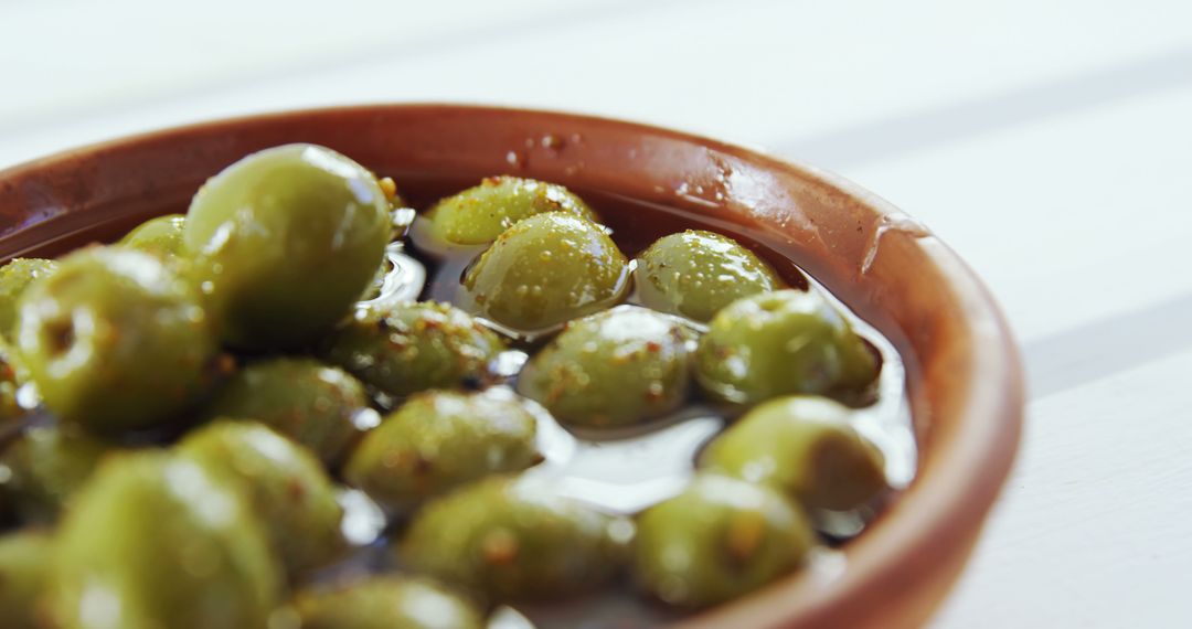 Close-Up of Green Olives in Ceramic Bowl with Herbs - Free Images, Stock Photos and Pictures on Pikwizard.com