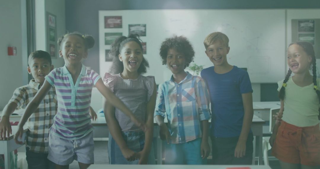 Diverse Group of Happy Schoolchildren in Classroom Celebrating Teamwork