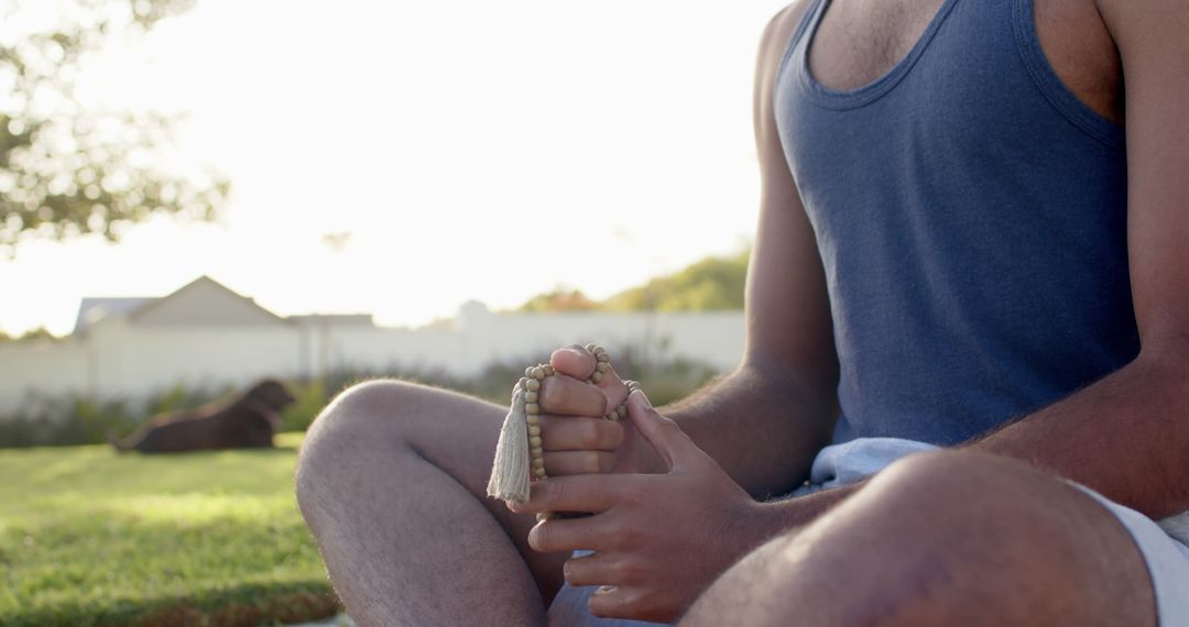 Man Meditating with Beads in Tranquil Outdoor Setting - Free Images, Stock Photos and Pictures on Pikwizard.com