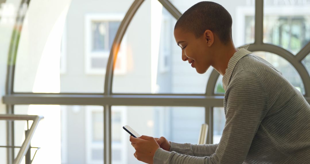 Young African American Woman Using Smartphone Indoors - Free Images, Stock Photos and Pictures on Pikwizard.com