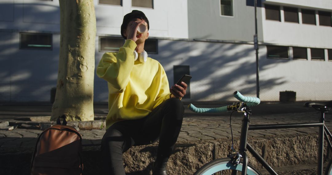 Man Relaxing with Coffee and Smartphone on Urban Street