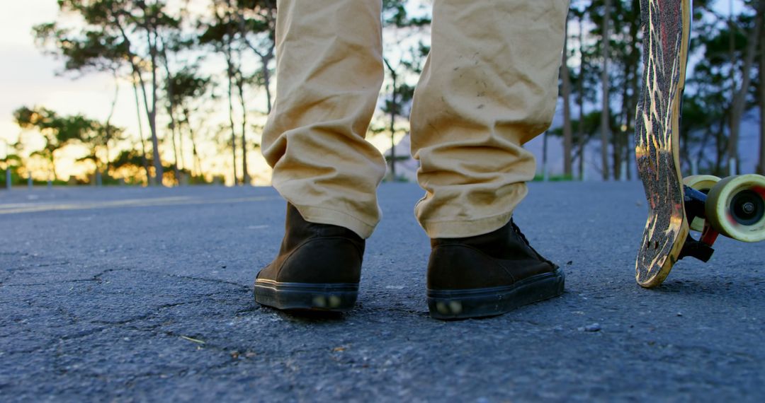 Close-up of Skater's Legs in Sneakers and Skateboard at Sunset - Free Images, Stock Photos and Pictures on Pikwizard.com