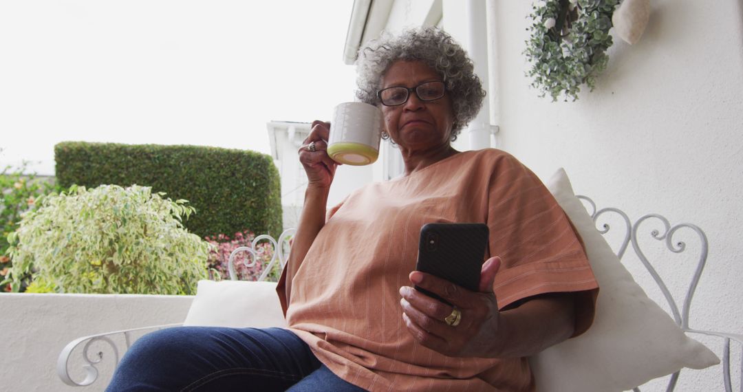 Senior Woman Relaxing on Porch with Smartphone and Coffee - Free Images, Stock Photos and Pictures on Pikwizard.com