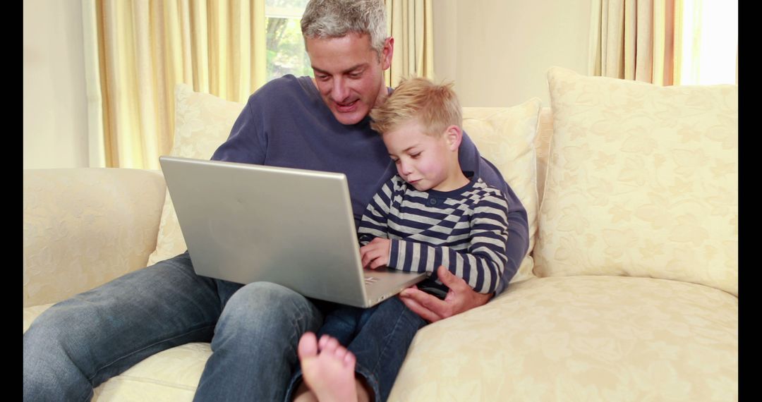 Father and Son Using Laptop on Cozy Couch - Free Images, Stock Photos and Pictures on Pikwizard.com