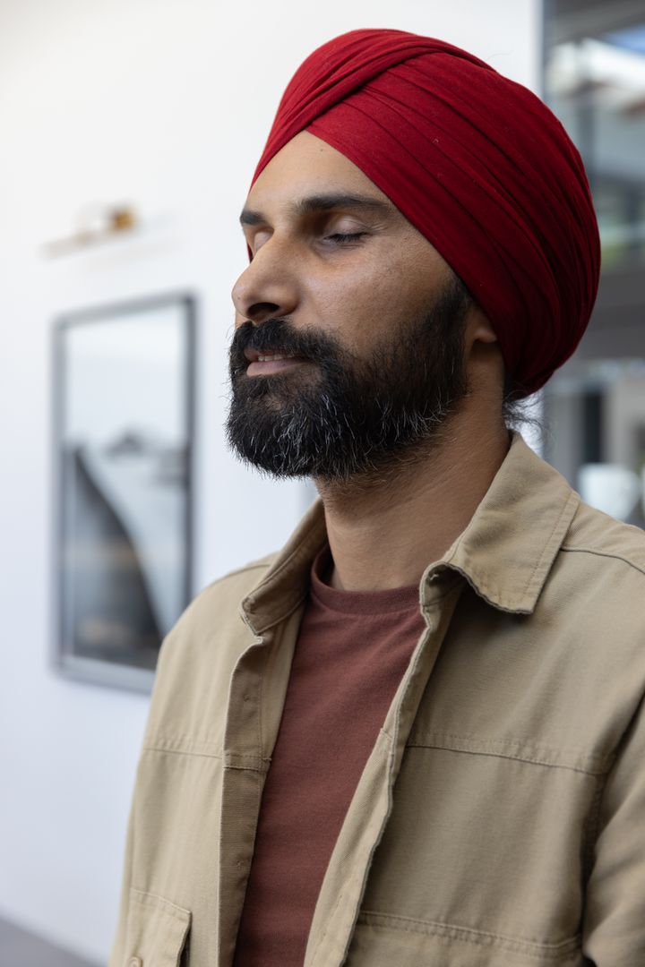 Contemplative Man with Red Turban in Modern Interior