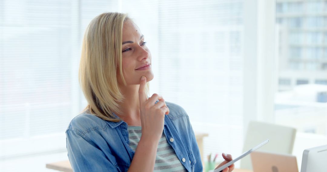 Thoughtful Woman Holding Tablet in Modern Office - Free Images, Stock Photos and Pictures on Pikwizard.com