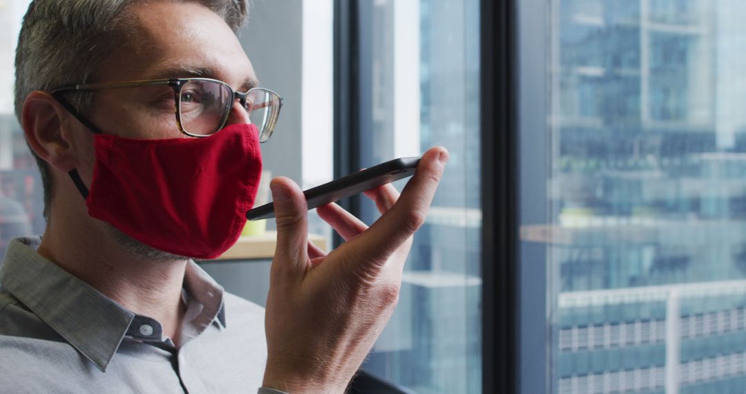 Businessman Wearing Red Mask Using Voice Assistant on Smartphone - Free Images, Stock Photos and Pictures on Pikwizard.com