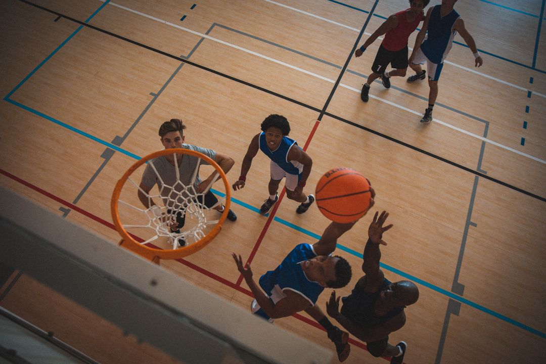 Overhead view of diverse male basketball players shooting for hoop and defending in court - Free Images, Stock Photos and Pictures on Pikwizard.com