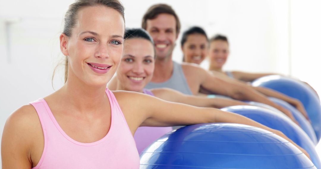 Fitness Class Holding Exercise Balls and Smiling at Camera