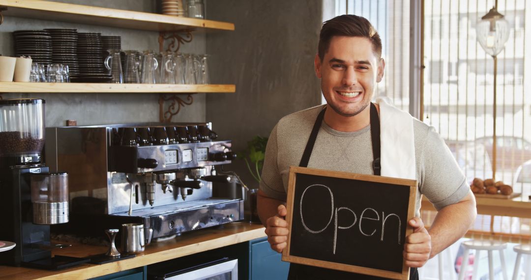 Smiling Cafe Owner Displaying 'Open' Sign