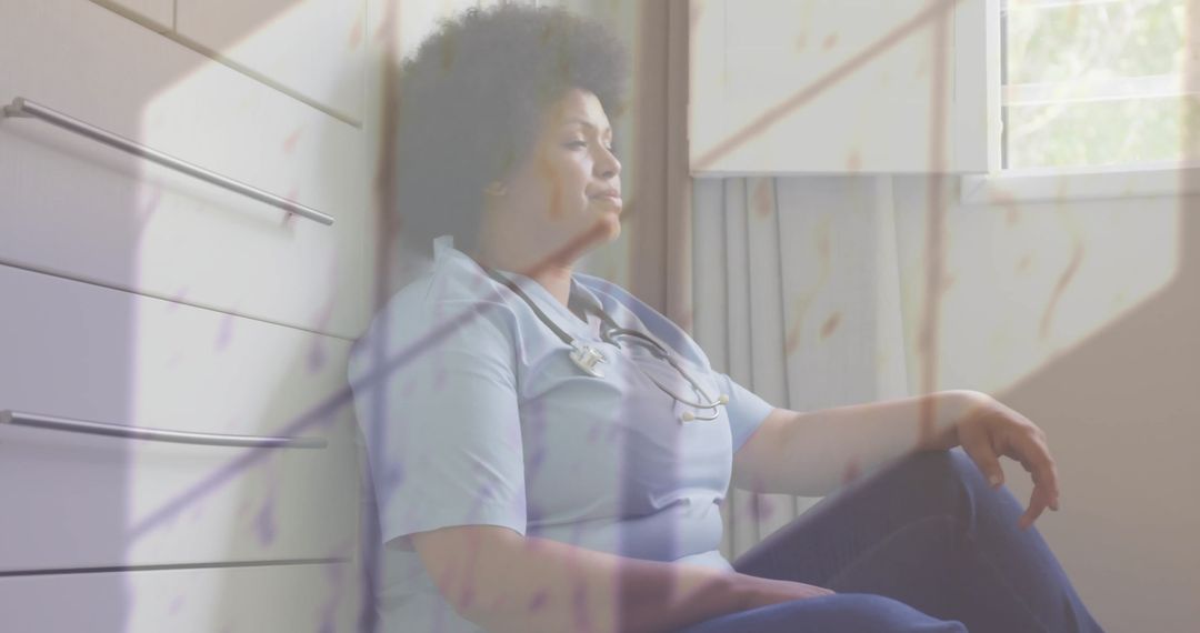 Stressed African American Doctor sitting in Hospital Corridor