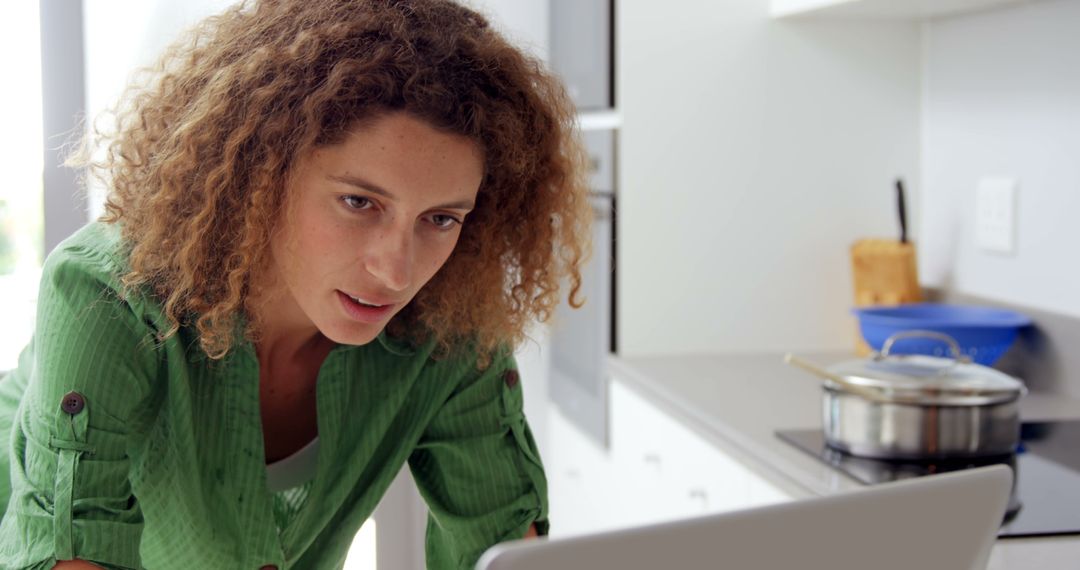 Woman with Curly Hair Working on Laptop in Kitchen - Free Images, Stock Photos and Pictures on Pikwizard.com