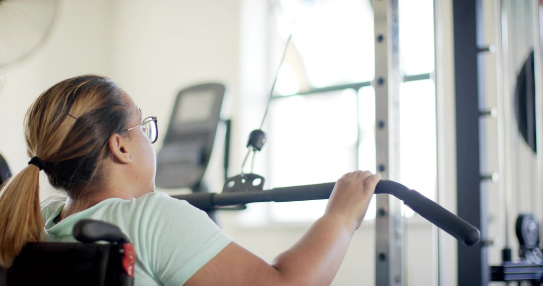 Woman in Wheelchair Performing Lat Pulldown Workout in Accessible Gym