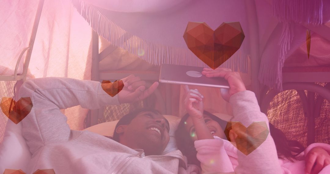 Sibling Bonding Over Tablet Surrounded by Digital Hearts