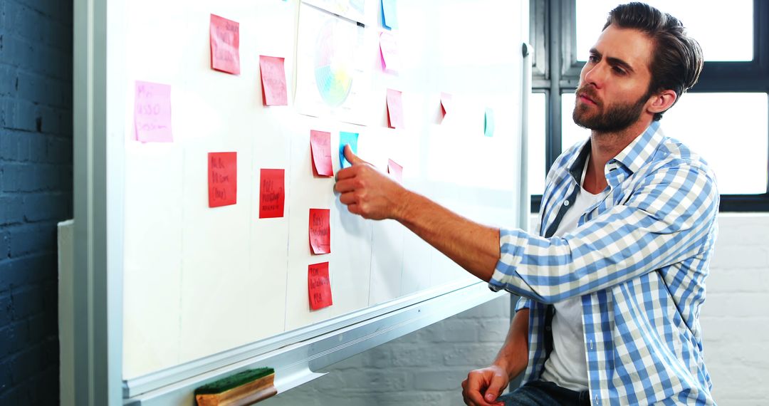 Focused Businessman Using Sticky Notes on Whiteboard - Free Images, Stock Photos and Pictures on Pikwizard.com