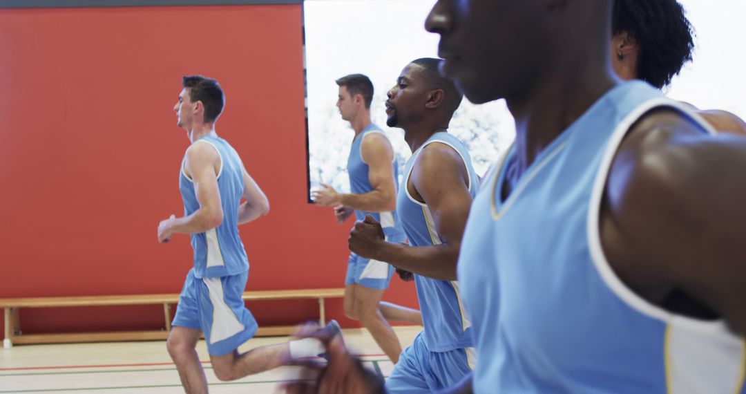 Group of Athletes Wearing Blue Jerseys Running Indoors - Free Images, Stock Photos and Pictures on Pikwizard.com