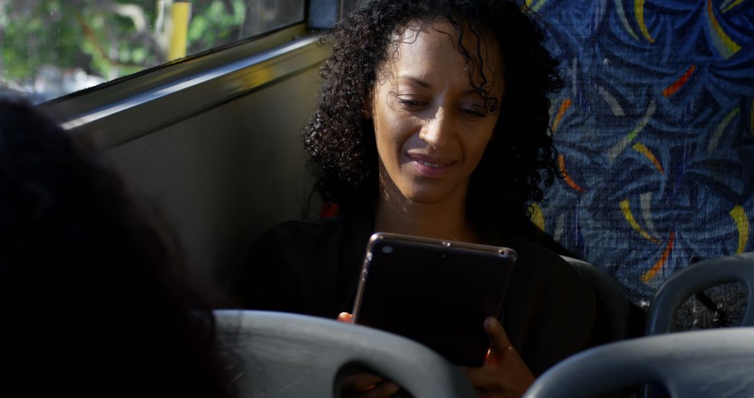 Smiling Woman Using Tablet During Bus Commute