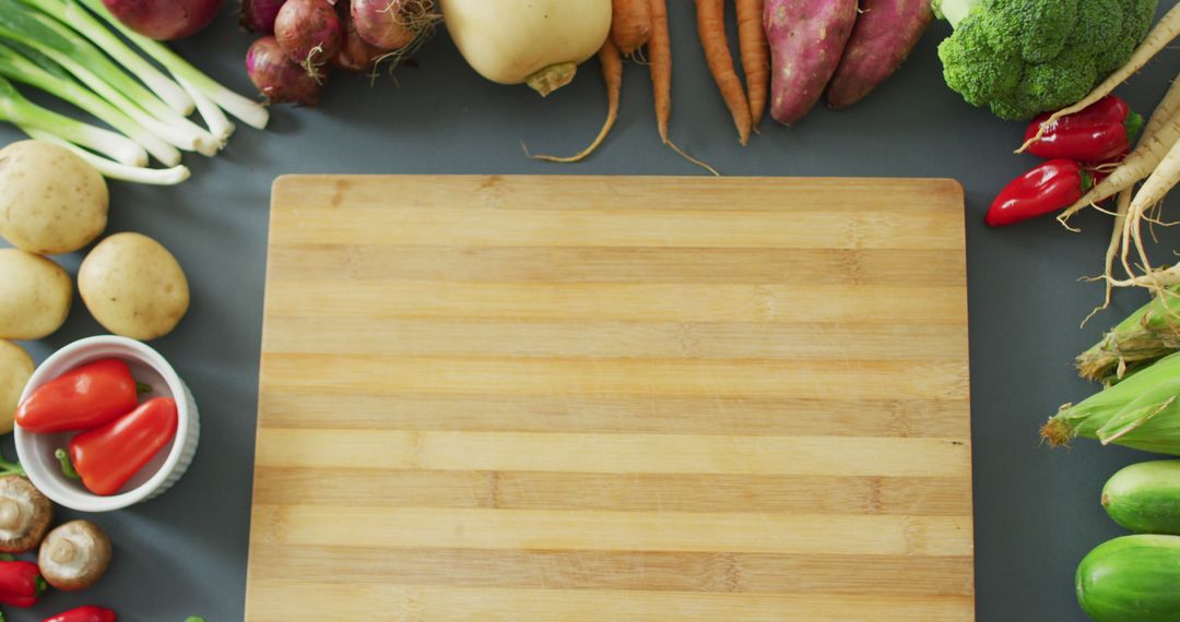 Wooden Cutting Board Surrounded by Assorted Fresh Vegetables - Free Images, Stock Photos and Pictures on Pikwizard.com