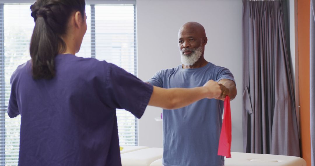 Elderly Man Exercising with Assistance Using Resistance Bands - Free Images, Stock Photos and Pictures on Pikwizard.com