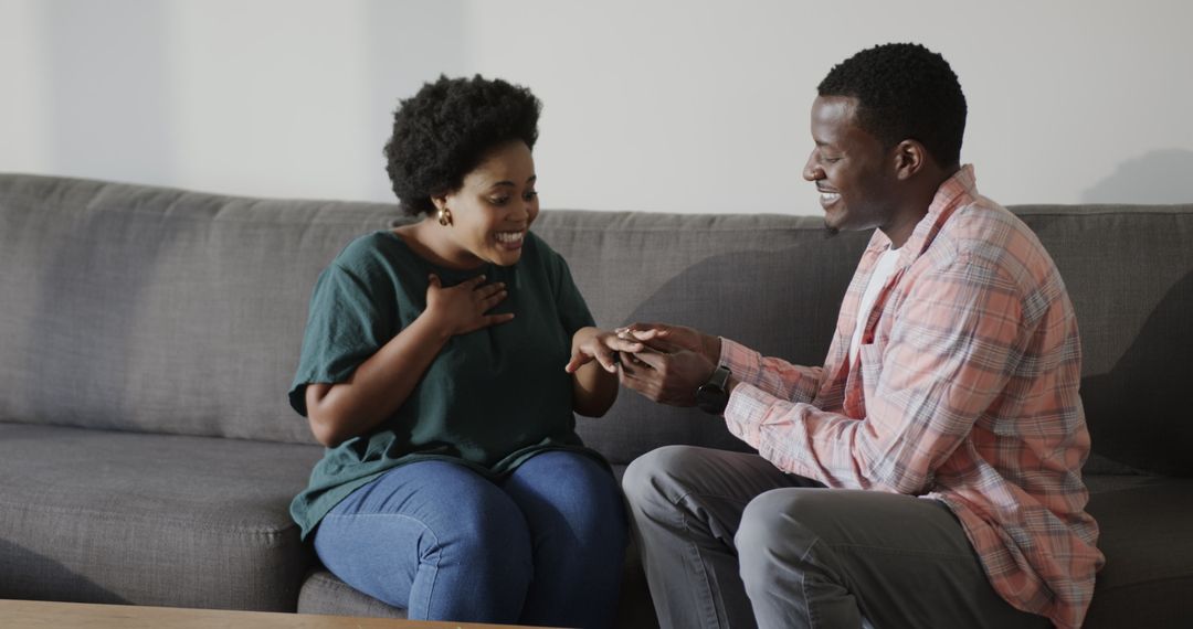 Man Proposing with Ring to Delighted Woman on Couch at Home