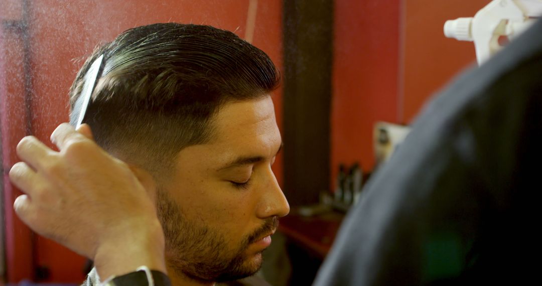A young Latino man is getting a haircut in a barbershop, with copy space - Free Images, Stock Photos and Pictures on Pikwizard.com