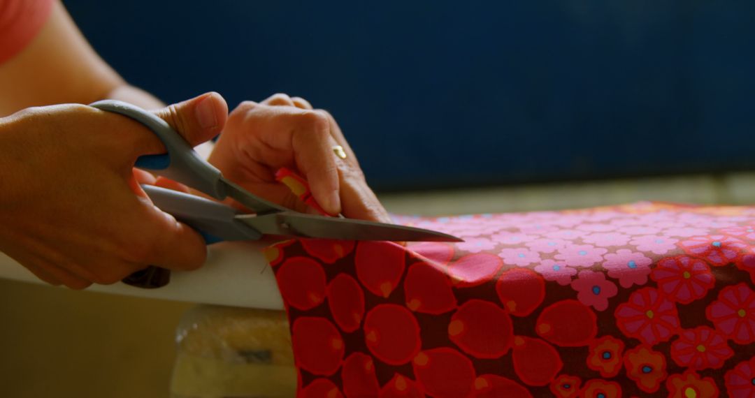 Hands Cutting Red Floral Fabric with Scissors - Free Images, Stock Photos and Pictures on Pikwizard.com