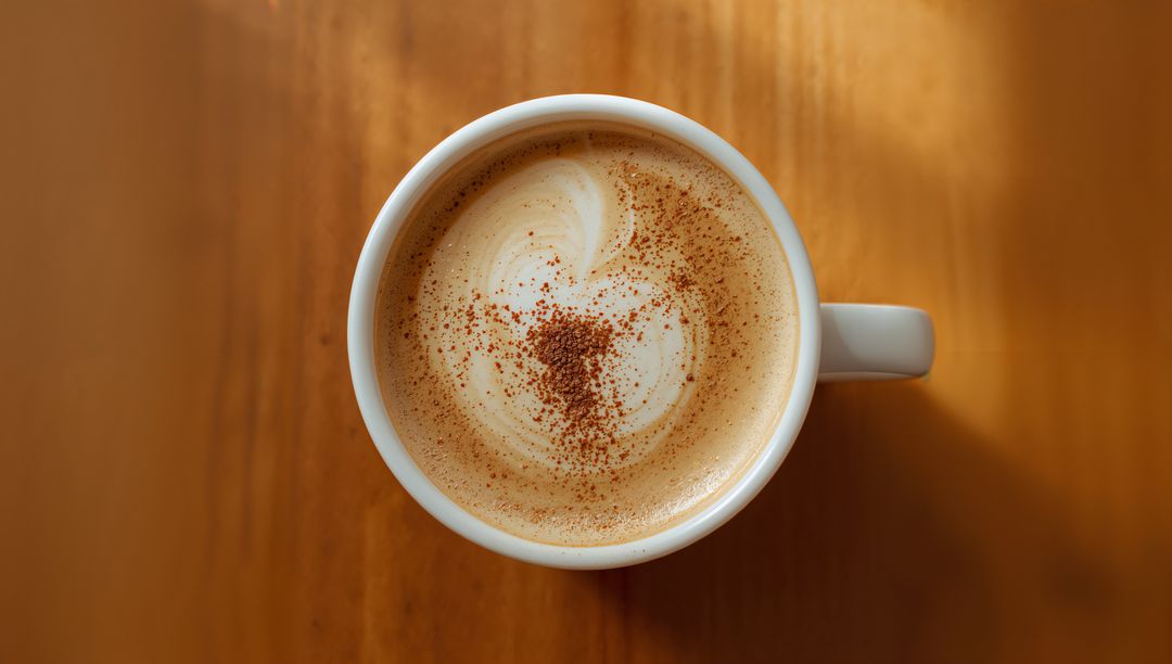 Top-Down Latte Art Heart with Cocoa Dust in White Mug on Warm Wooden Table