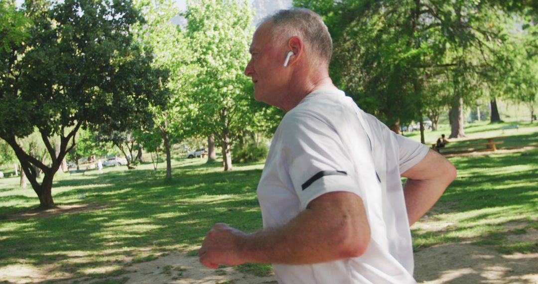 Senior Man Jogging in Park with Earbuds - Free Images, Stock Photos and Pictures on Pikwizard.com