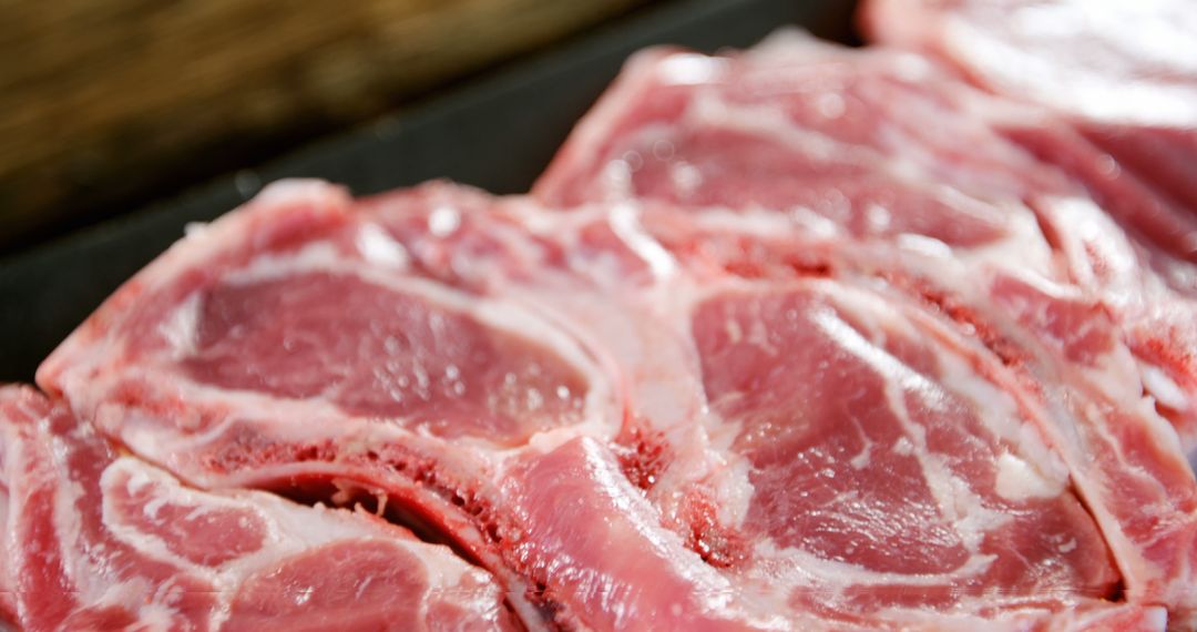 Fresh Raw Lamb Chops with Rich Marbling on Dark Surface - Free Images, Stock Photos and Pictures on Pikwizard.com