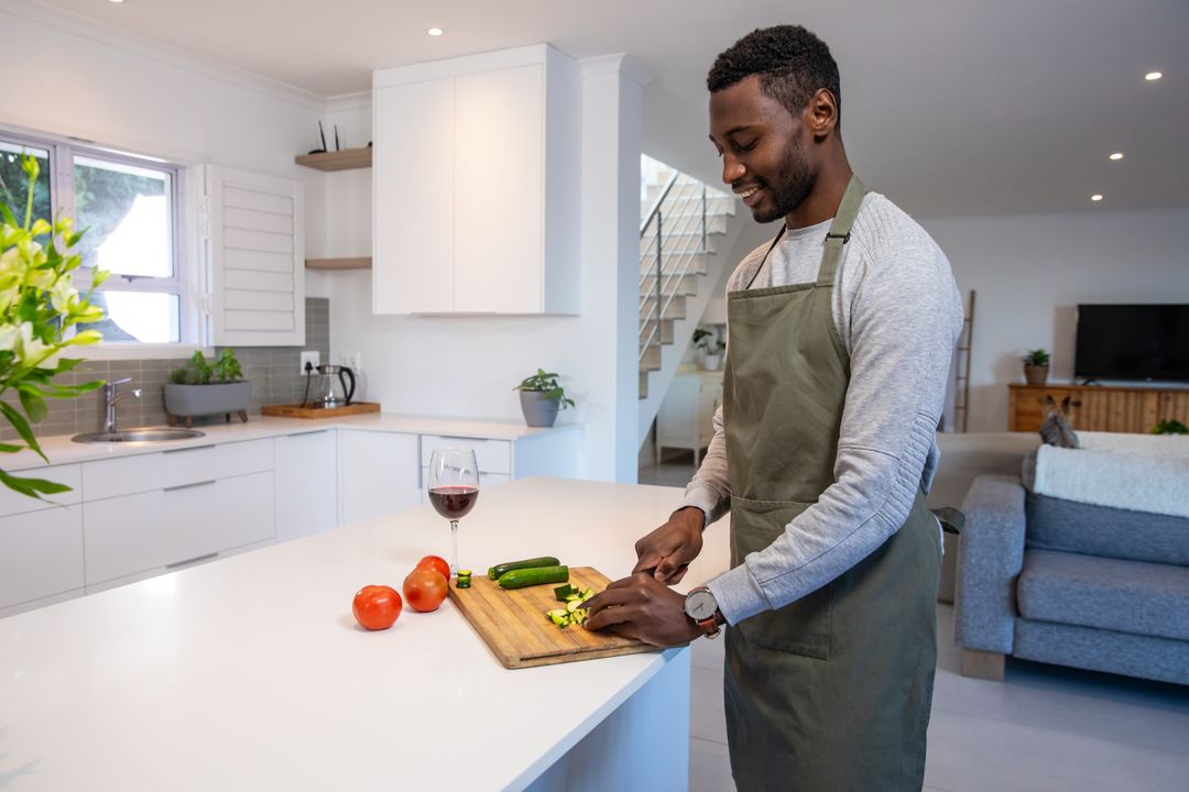 Man Cooking at Home Slicing Vegetables with Wine Glass Nearby