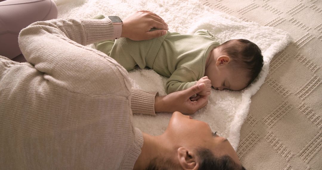 Mother Enjoying Tender Moment with Sleeping Baby on Soft Blanket