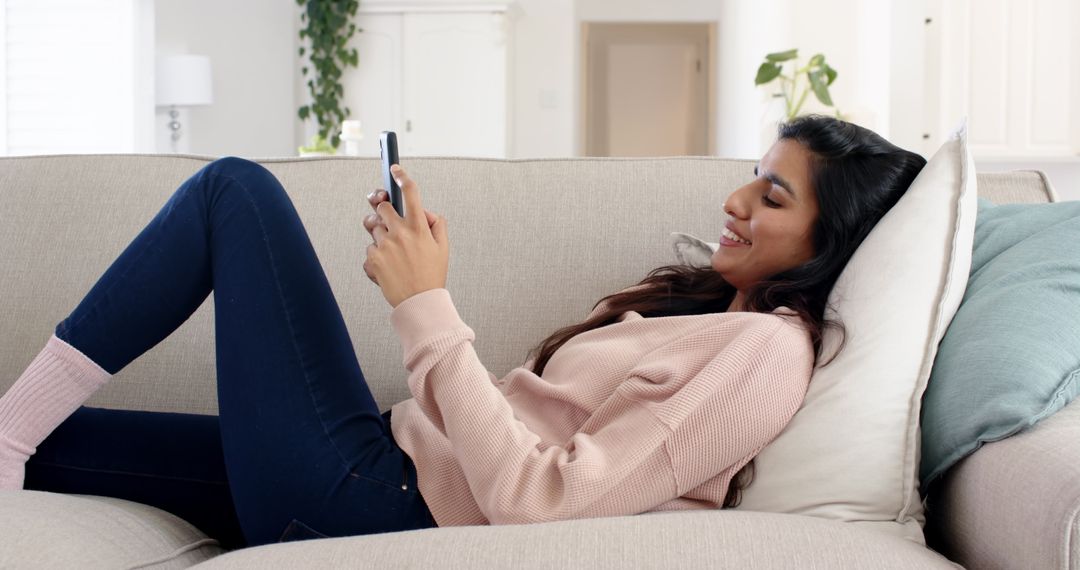 Relaxed Woman Reclining on Sofa with Smartphone at Home
