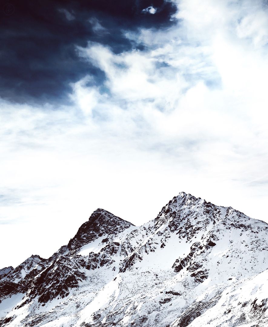 Snow-covered majestic mountain peaks under a dramatic sky - Free Images, Stock Photos and Pictures on Pikwizard.com