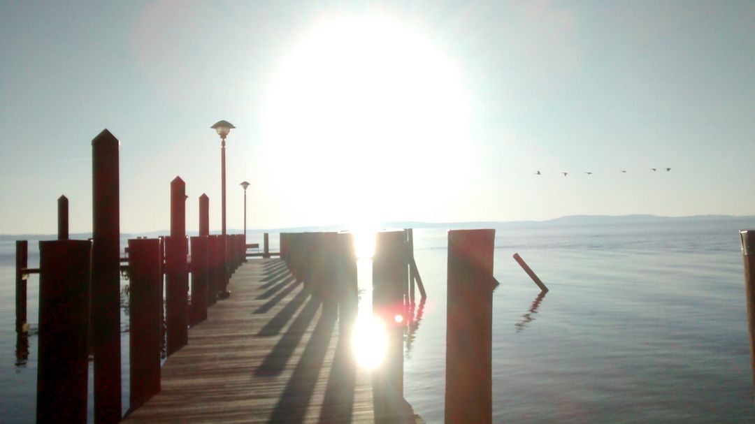 Sunlit Pier on Calm Waters at Sunset - Free Images, Stock Photos and Pictures on Pikwizard.com