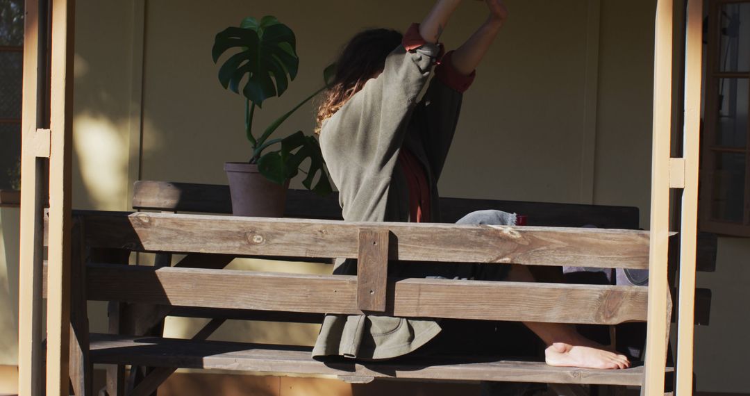 Person Stretching on Wooden Bench in Warm Sunlight - Free Images, Stock Photos and Pictures on Pikwizard.com