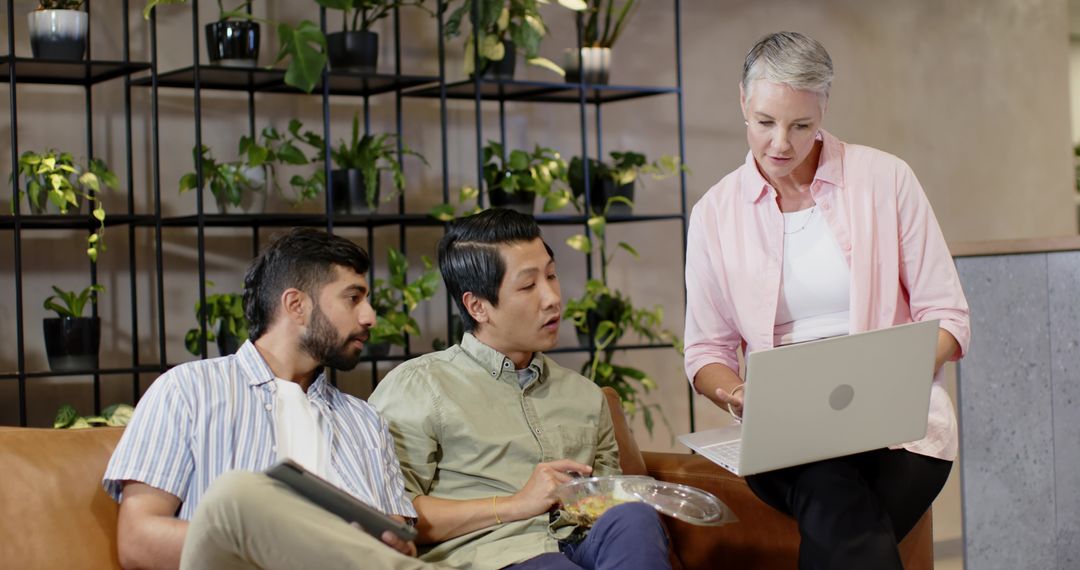 Diverse Team Collaborating in Modern Office Lounge with Plant Shelves