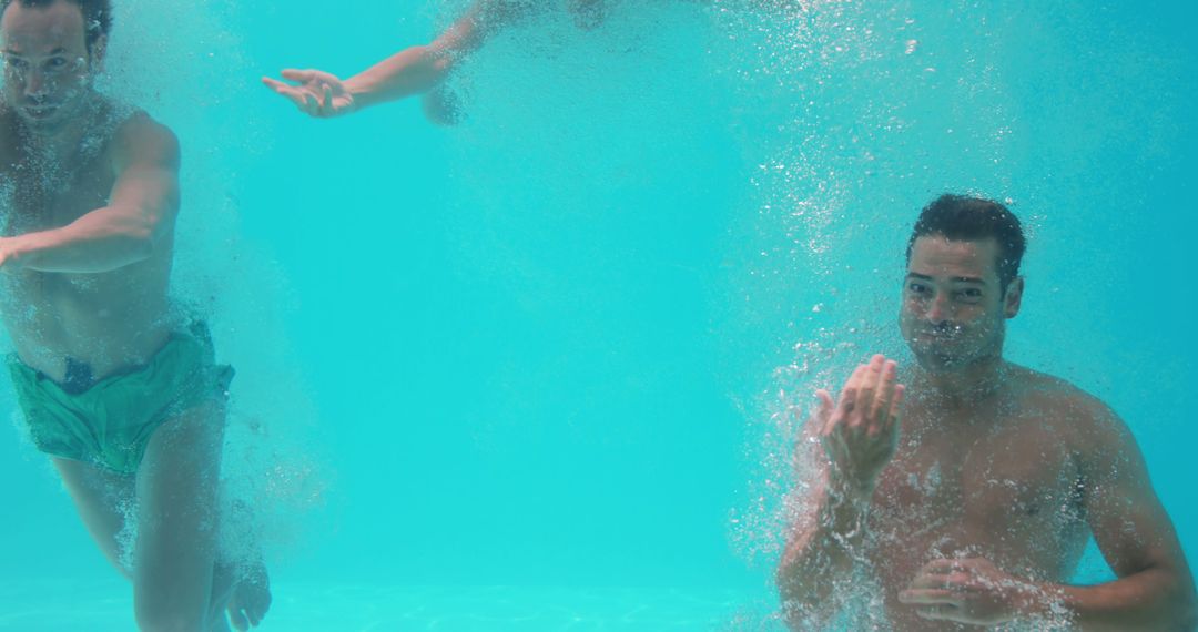 Friends underwater in swimming pool  - Free Images, Stock Photos and Pictures on Pikwizard.com