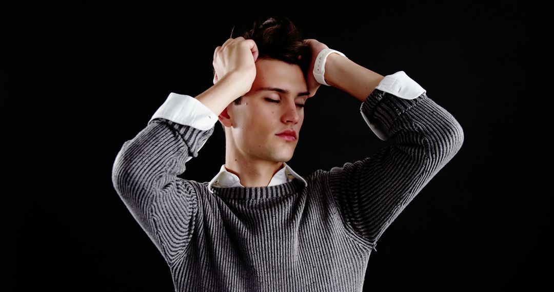 Worried Young Man Holding Head Against Black Background - Free Images, Stock Photos and Pictures on Pikwizard.com