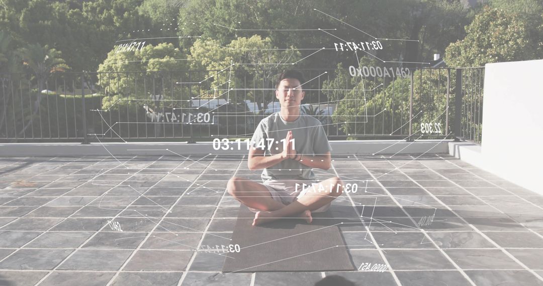 Asian man meditating on rooftop terrace with holographic data overlays for wellness tech