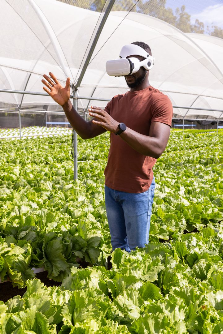 African American Man Using VR in Greenhouse for Sustainable Farming
