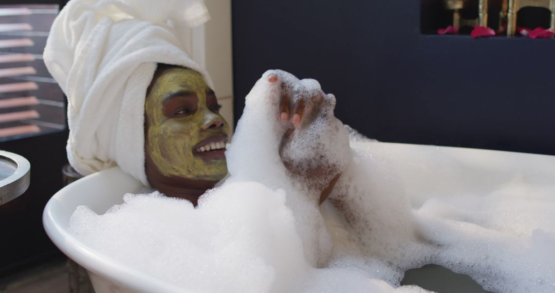 Smiling african american woman with towel and mask taking bath in bathroom - Free Images, Stock Photos and Pictures on Pikwizard.com