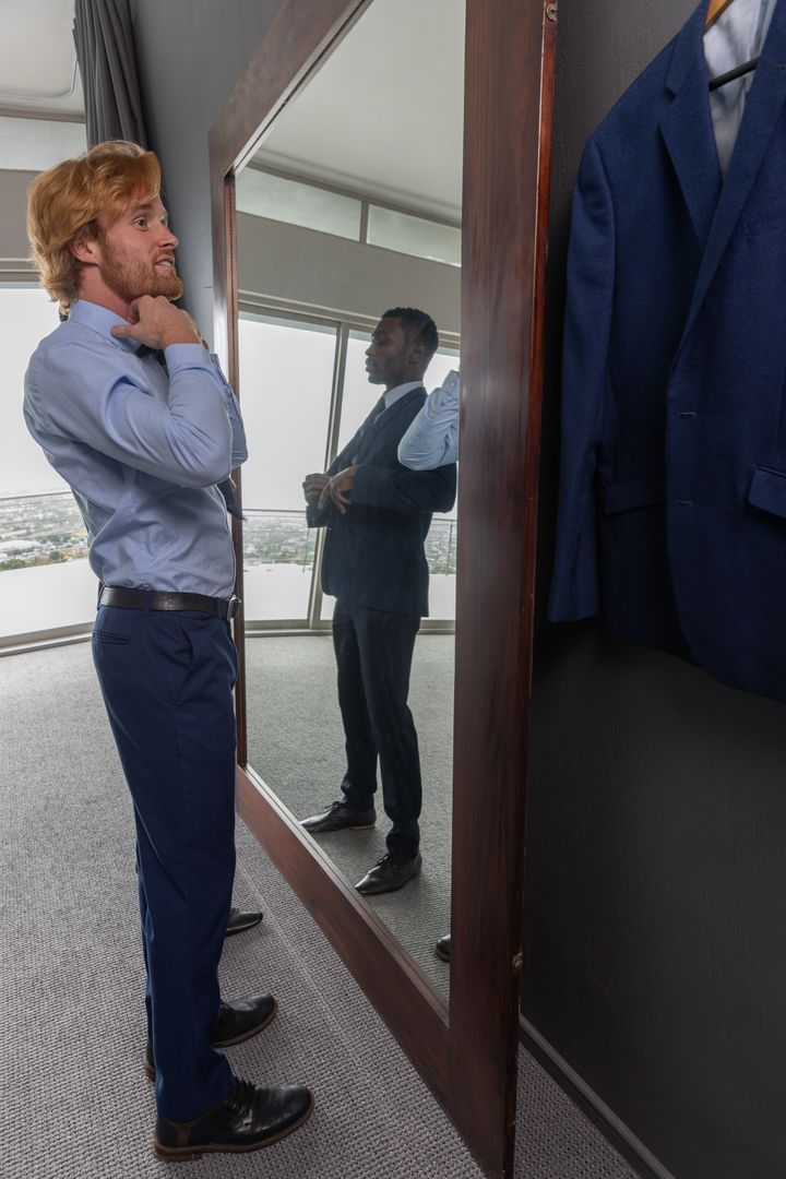 Professional Men Attiring Themselves with Elegance in Modern Hotel Room