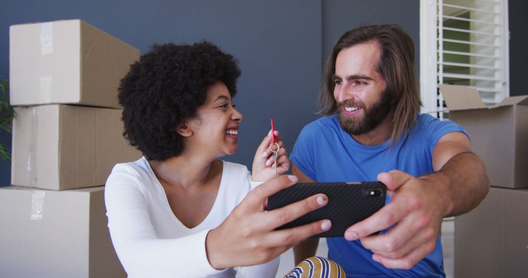 Cheerful Couple Celebrating New Home with Selfie Amid Moving Boxes - Free Images, Stock Photos and Pictures on Pikwizard.com