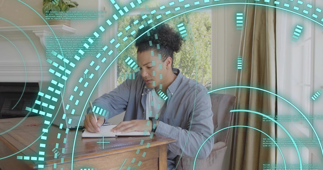 Young man writing in notebook at wooden desk with teal augmented reality HUD overlay