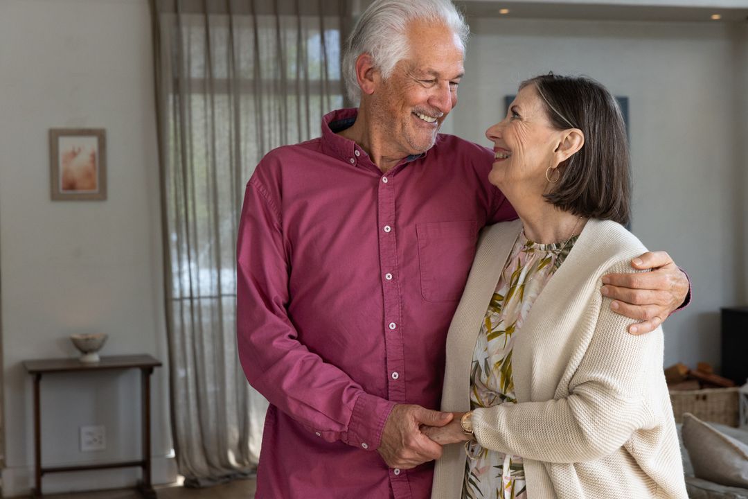 Senior Couple Embracing and Smiling in Warm Living Room