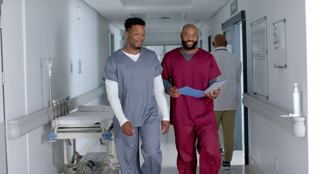 Two Male Medical Professionals Conversing in Hospital Corridor - Free Images, Stock Photos and Pictures on Pikwizard.com