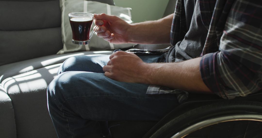 Person in Wheelchair Holding Cup of Tea Relaxing at Home - Free Images, Stock Photos and Pictures on Pikwizard.com