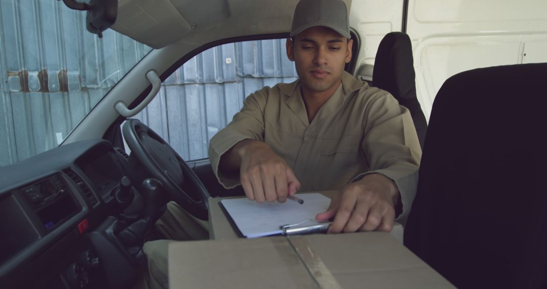 Delivery Driver Checking Clipboard in Van - Free Images, Stock Photos and Pictures on Pikwizard.com